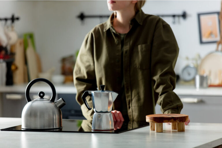 donna in cucina fa il caffè