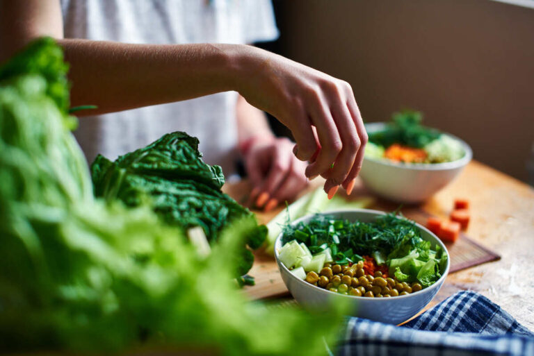 donna prepara un pasto a base di vegetali